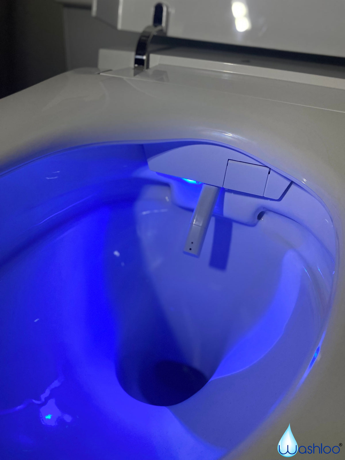 A studio product photograph of a standalone Washloo smart toilet highlighting its soft blue ambient LED nightlight illuminating the interior of the ceramic bowl on a clean white background.